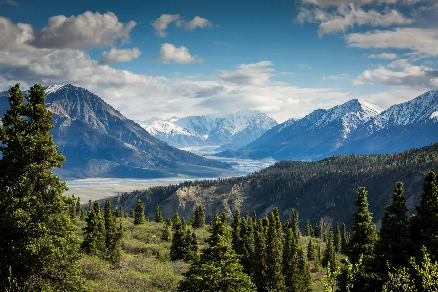 A mountain lake reflecting rocky peaks and evergreen trees.